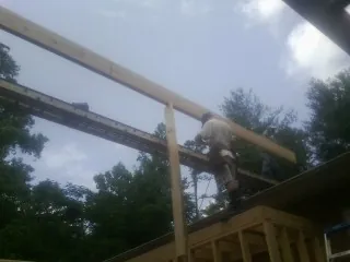 Carpenter setting a ridge beam over a new addition frame — Ice Dam Removal by Roofing Brothers in Fountain Inn