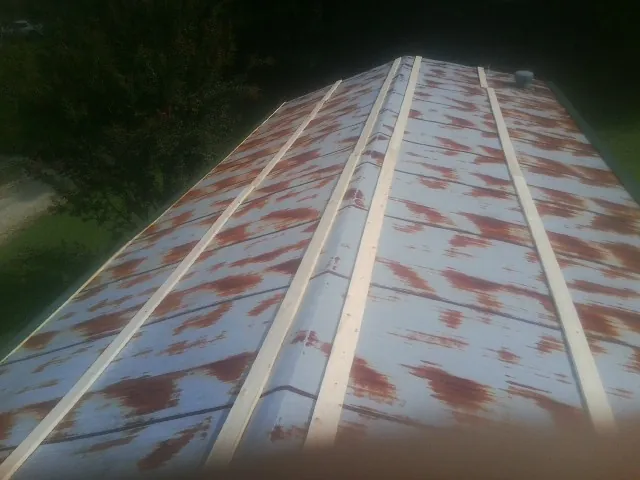 Rusted metal roof panels with new wood purlins before replacement — Storm Damage Roof Repair in Fountain Inn by Roofing Brothers