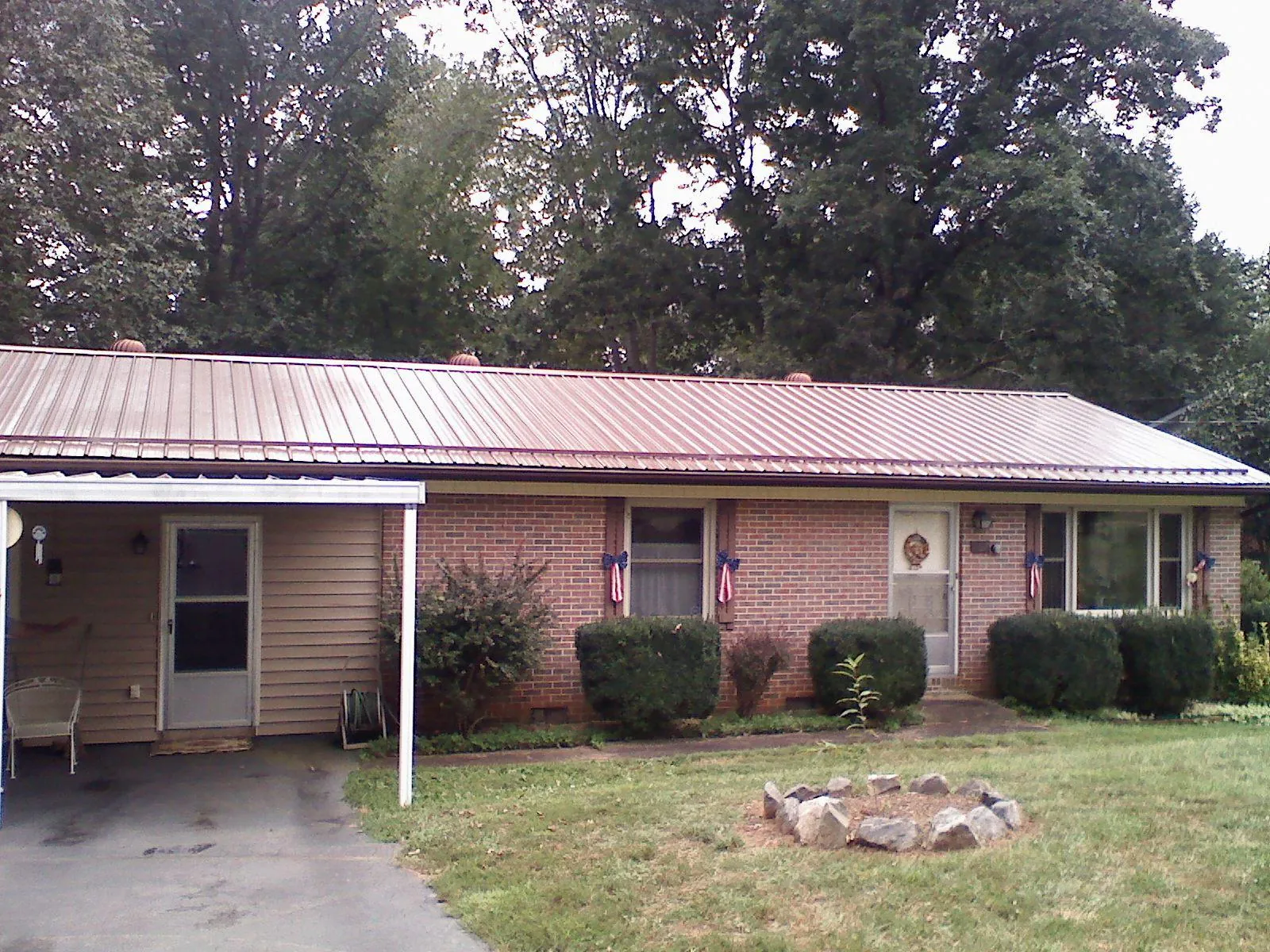Bronze metal roof and carport on a brick ranch home — Roof Repair work by our crew in Fountain Inn